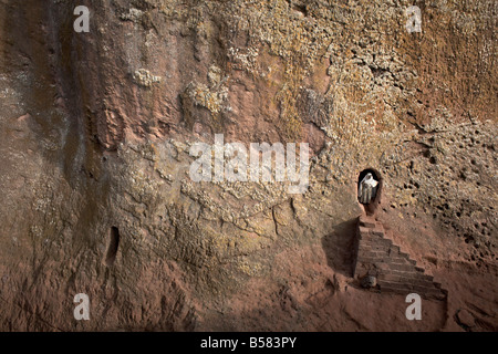 Une femme sort d'un tunnel menant à l'église rupestres de Bet Amanuel, à Lalibela, Ethiopie, Afrique Banque D'Images