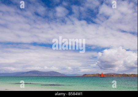 Bateau à voile rouge au large de la plage de Traigh Bhan, Iona, Son d'Iona, Ecosse, Royaume-Uni, Europe Banque D'Images