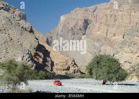 Route de gravier le long de l'étage de wadi profond au-dessous des falaises de calcaire, Wadi Bani Habib, Jabal Akhdar, dans le nord de l'Oman, Middle East Banque D'Images