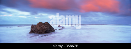 Widemouth Bay au lever du soleil, avec des rochers et les nuages de tempête rouge frais généraux, près de Bude, Cornwall, Angleterre, Royaume-Uni Banque D'Images