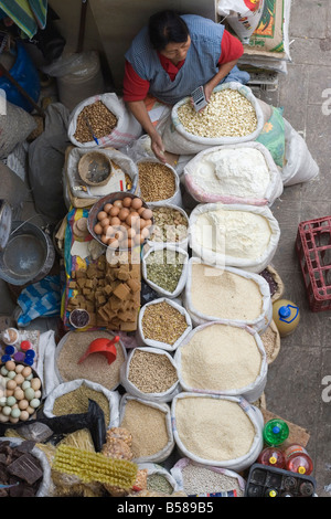 Femme vendant des oeufs et d'autres produits séchés dans le marché de Agosto sur la Calle Larga, Cuenca, Azuay Province, l'Équateur Banque D'Images