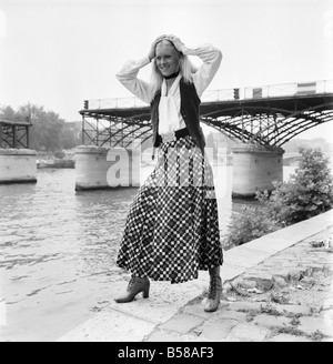 Paris modes. Yves Saint Laurent - Rive Gauche - Christine, 20 ans, modèle sur les bords de Seine Port mi-laine vérifier kilt avec chemisier blanc et gilet noir. Juillet 1970 70-6876-007 Banque D'Images