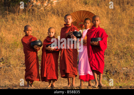 Nun avec moines novices holding alms boules à Mingun Paya Mingun Mandalay Myanmar Birmanie Asie Banque D'Images