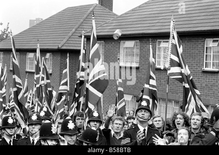 Lewisham Riot 1977 : les policiers escortant un Front National rally à travers Lewisham regarder comme le premier de nombreux missiles sont lancés sur les manifestants et leur escorte de police. La marche a été confronté à un comptoir de l'aile gauche de démonstration qui ont déclenché des émeutes par des extrémistes des deux côtés . Août 1977 77-04357-007 Banque D'Images