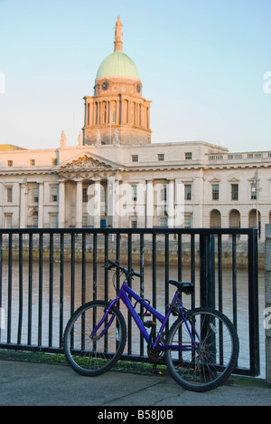 Un vélo verrouillé sur les rails à la recherche dans la direction de l'Custom House à Dublin Banque D'Images