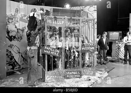 Loisirs : programme : Tiswas : Daily Mirror's Sue Tranter, passé le samedi matin dans la cage sur le programme Tiswas à Birmingham d'être fouettés avec mousse "crème anglaise" tartes et douche froide. Petite fille obtient une épaule ride à l'extérieur de la cage. Janvier 1981 81-00026-001 Banque D'Images