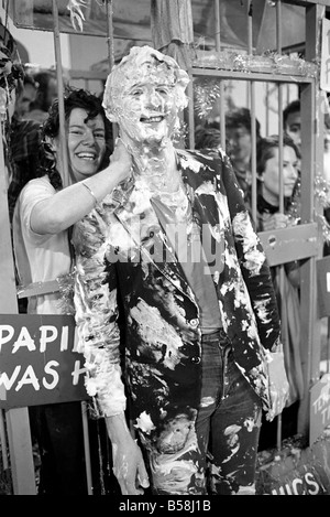 Loisirs : programme : Tiswas : Daily Mirror's Sue Tranter, passé le samedi matin dans la cage sur le programme Tiswas à Birmingham d'être fouettés avec mousse "crème anglaise" tartes et douche froide. Elle s'empare d'une crème anglaise couverts Chris Tarrant.;Janvier 1981 81-00026-011 Banque D'Images