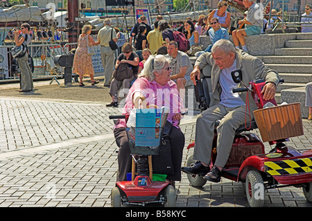 Deux personnes à l'aide de la mobilité électrique scooters pour visiter Bristol Harbour Festival Banque D'Images