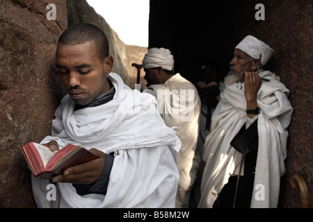 Un homme lit la Bible à l'église rupestres de Bet Maryam, à Lalibela, Site du patrimoine mondial de l'UNESCO, l'Éthiopie, l'Afrique Banque D'Images