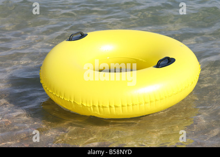 Grande piscine gonflable jaune Ring flottant sur la mer Banque D'Images
