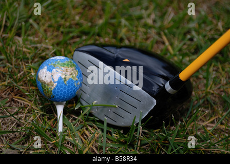 Une balle de golf sur la terre se trouve sur un tee de golf Banque D'Images