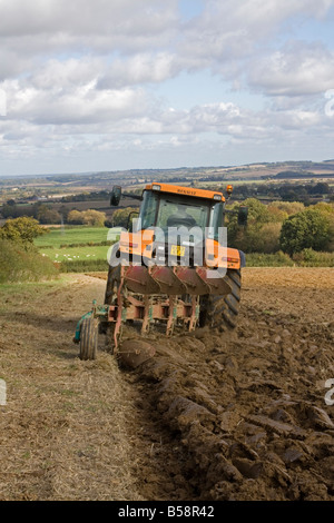 Agriculteur en champ de labour tracteur rouge UK Cotswolds Banque D'Images