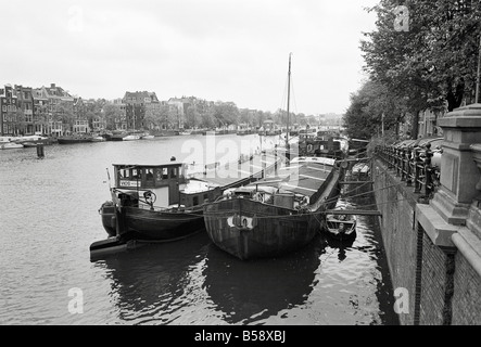 Image en noir et blanc de barges sur la rivière Amstel à Amsterdam Banque D'Images