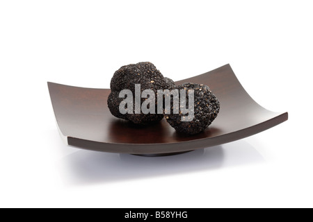 Truffes noires sur bol en bois, close-up Banque D'Images