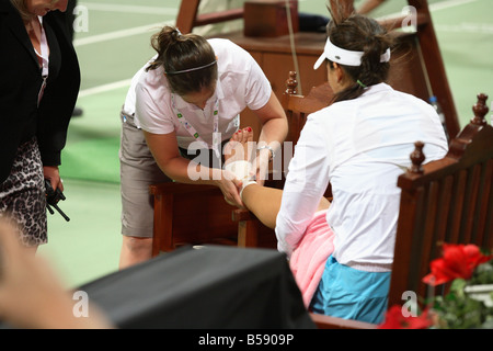 La star du tennis pro Ana Ivanovic a une entorse à la cheville bandée à l'Open 2008 de Doha Banque D'Images