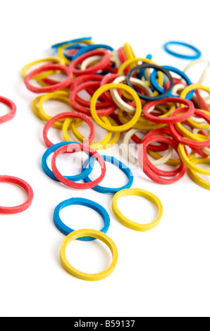 Bandes de caoutchouc colorées dispersées sur une surface blanche dans un arrangement créatif montrant différentes tailles et couleurs Banque D'Images