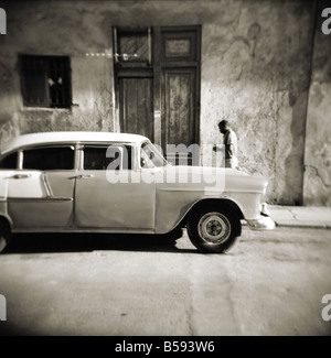 Image prise avec un Holga 120 film format moyen de toy camera man walking passé vieille voiture américaine, La Havane, Cuba, Antilles Banque D'Images
