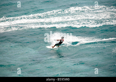 Waterskier sur planche de surf ski nautique tracté par l'homme sur le jet ski en mer au large de l'Île Stradbroke-nord Queensland QLD Australie Banque D'Images