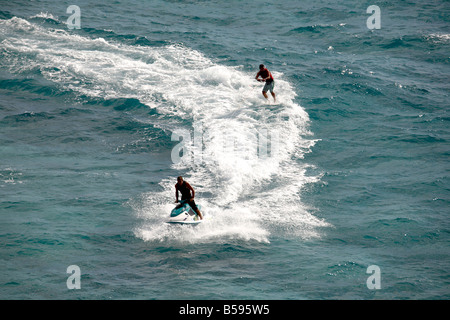 Waterskier sur planche de surf ski nautique tracté par l'homme sur le jet ski en mer au large de l'Île Stradbroke-nord Queensland QLD Australie Banque D'Images