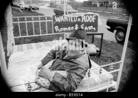 Romeo Meli accroupi contre la pluie battante dans un lit comme les camions de le percer à jour passé. C'est une sieste sur l'herbe de la division d'une double voie de chariot dans une tentative de sauver son vouée cottage. Il est le dernier homme de gauche regrettent la disparition de la déserté de Groes près de Port Talbot, Glam. Les 21 autres familles ont déjà quitté disparu. Avril 1975 75-1947-004 Banque D'Images