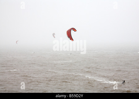 Les gens kite-surf sur la mer dans le brouillard dans la baie d'eau douce Ile de Wight Angleterre UK Banque D'Images