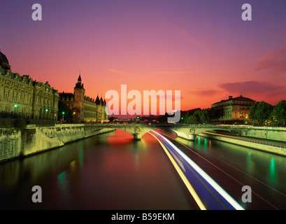 Bateau-mouche Bateau de tourisme floue en passant sous un pont sur la Seine la nuit Paris France Europe Banque D'Images