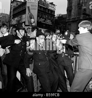 Première du film du nouveau film sous-marin jaune des Beatles au London Pavilion. ;Un policier obtient son chapeau de nouveau par un passant Banque D'Images