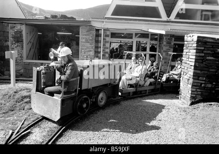 L'industrie minière : : 'Britain's Beauty Spot plus laid' : Blaenau Ffestiniog, un village de mineurs d'ardoise galloise, où les chefs des scories giat tour Ardoise haut au-dessus des toits et plonger jusqu'aux portes des maisons, est devenu une des principales attractions touristiques. Plus de 2 000 touristes par jour troupeau de faire une visite guidée autour de la mine d'Ardoise de Llechwedd - menées par les mineurs, les mêmes hommes qui avaient l'habitude d'une griffe peu dangereux et vivre de la montagne lors de l'extraction de l'ardoise est à son apogée. Evan Richards, 63 le off avec un autre chargement de train de touristes autour de la mine Banque D'Images