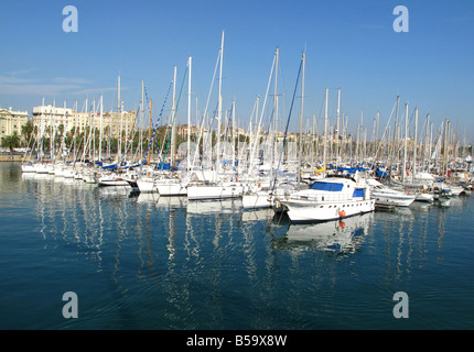 Yachts et voiliers amarrés contre un ciel bleu dans la marina à Barcelone, Espagne Banque D'Images