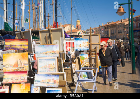 Les touristes regarder peintures qui sont affichées dans le port de Saint-Tropez sur la Cote d'Azur / Provence / Sud de la France Banque D'Images