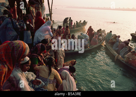 Les femmes prennent à des bateaux sur le fleuve Ganges au cours de Surya Puja adoration du Soleil Festival Varanasi Uttar Pradesh Inde Asie Banque D'Images