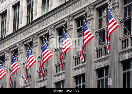 Des drapeaux américains dans la construction d'entreprise Saks sur la Cinquième Avenue de Manhattan New York City Banque D'Images