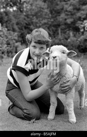 Femme l'alimentation et le toilettage Larry l'agneau. Juin 1980 Banque D'Images