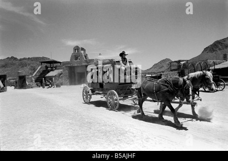 Le point culminant d'une visite à Old Tucson, le célèbre film emplacement dans le désert de l'Arizona, c'est faire l'expérience d'un "live" de coups dans les rues de la ville. Contrairement à la cowboy poussiéreux portant des bottes de daim talon haut et le combattre dehors sur les marches de la Banque mondiale, de l'autre côté de la rue est bordée de touristes vêtus de T-shirts, de sports et de chaussures de tir photos du tireur de combat et sheriff.. Notre photo montre:La Malle-Poste arrivant en ville. Juin 1980 Banque D'Images