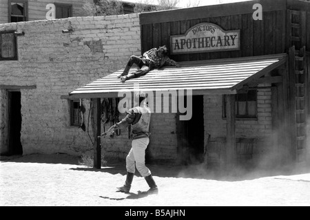 Le point culminant d'une visite à Old Tucson, le célèbre film emplacement dans le désert de l'Arizona, c'est faire l'expérience d'un "live" de coups dans les rues de la ville. Contrairement à la cowboy poussiéreux portant des bottes de daim talon haut et le combattre dehors sur les marches de la Banque mondiale, de l'autre côté de la rue est bordée de touristes vêtus de T-shirts, de sports et de chaussures de tir photos du tireur de combat et le shérif. Juin 1980 Banque D'Images