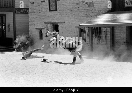 Le point culminant d'une visite à Old Tucson, le célèbre film emplacement dans le désert de l'Arizona, c'est faire l'expérience d'un "live" de coups dans les rues de la ville. Contrairement à la cowboy poussiéreux portant des bottes de daim talon haut et le combattre dehors sur les marches de la Banque mondiale, de l'autre côté de la rue est bordée de touristes vêtus de T-shirts, de sports et de chaussures de tir photos du tireur de combat et sheriff.. Notre photo montre : Juin 1980 Banque D'Images