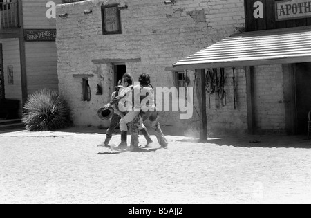 Le point culminant d'une visite à Old Tucson, le célèbre film emplacement dans le désert de l'Arizona, c'est faire l'expérience d'un "live" de coups dans les rues de la ville. Contrairement à la cowboy poussiéreux portant des bottes de daim talon haut et le combattre dehors sur les marches de la Banque mondiale, de l'autre côté de la rue est bordée de touristes vêtus de T-shirts, de sports et de chaussures de tir photos du tireur de combat et sheriff.. Notre photo montre : Juin 1980 Banque D'Images