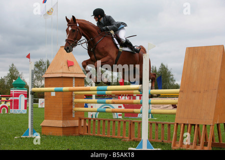 Jeune dame-cavalier sautant sur le dos d'un cheval allemand Banque D'Images