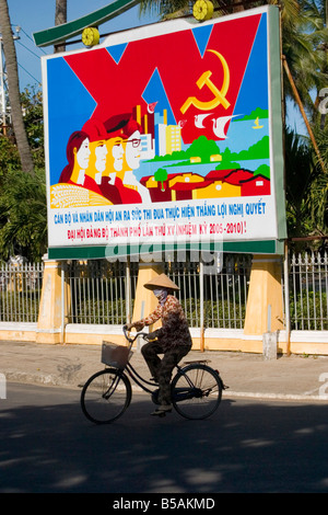 Les cycles de la femme vietnamienne communiste passé Poster, Hoi An, Vietnam Banque D'Images