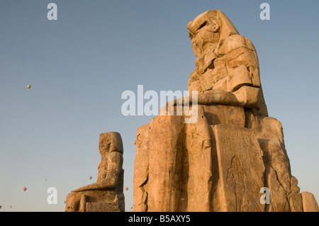 Les colosses de Memnon, qui sont deux énormes statues de pierre représentant le Pharaon Amenhotep III faits de blocs de grès quartzite près de Louxor, Egypte Banque D'Images