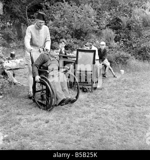 Le handicap et les jeunes : Tommy Hoare les apodes boy-scout vu ici profiter de camping. Juillet 1955 Banque D'Images