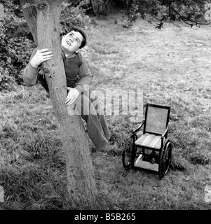 Le handicap et les jeunes : Tommy Hoare les apodes boy-scout vu ici profiter de camping, vu ici l'ascension d'une arborescence. Juillet 1955 Banque D'Images