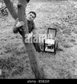 Le handicap et les jeunes : Tommy Hoare les apodes boy-scout vu ici profiter de camping, vu ici l'ascension d'une arborescence. Juillet 1955 Banque D'Images