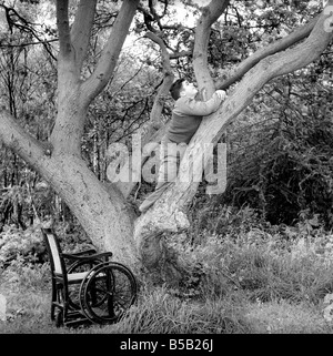 Le handicap et les jeunes : Tommy Hoare les apodes boy-scout vu ici profiter de camping, vu ici l'ascension d'une arborescence. Juillet 1955 Banque D'Images