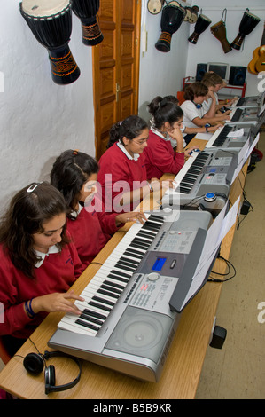 CLAVIERS de CLASSE musicale les élèves de Teenage s'entraîner ensemble sur des claviers électroniques dans la classe de musique scolaire Banque D'Images