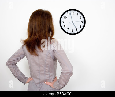 Businesswoman in office regarder l'horloge Banque D'Images