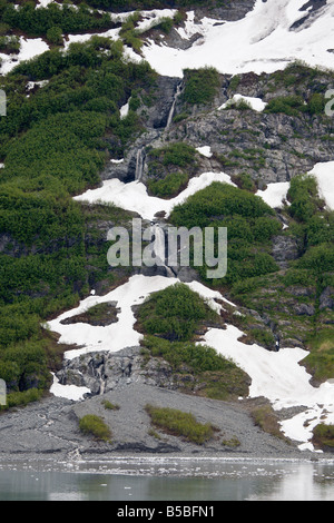 L'écoulement glaciaire passé rocky mountain waterfall in désenchantement Bay en Alaska Banque D'Images