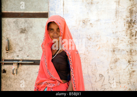 Une jeune femme dans un village indien sari rouge, Rajasthan, Inde Banque D'Images