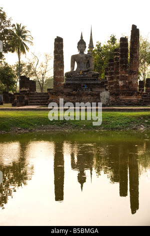 Statue de Bouddha dans le temple Wat Mahathat parc historique de Sukhothai en Thaïlande, au coucher du soleil Banque D'Images