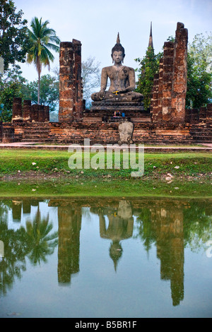 Statue de Bouddha dans le temple Wat Mahathat parc historique de Sukhothai en Thaïlande, au coucher du soleil Banque D'Images